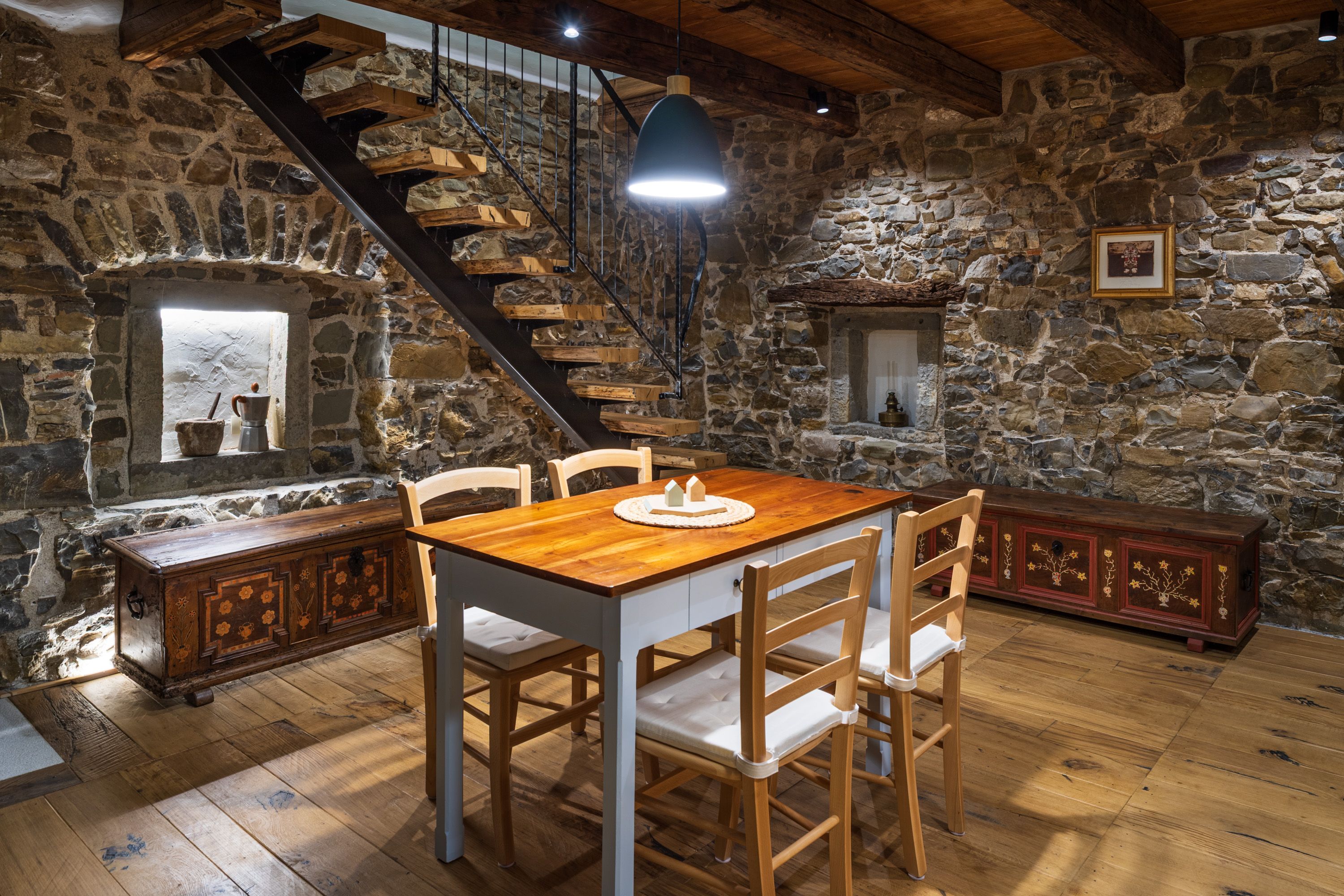 Stone lower level with staircase and antique chests